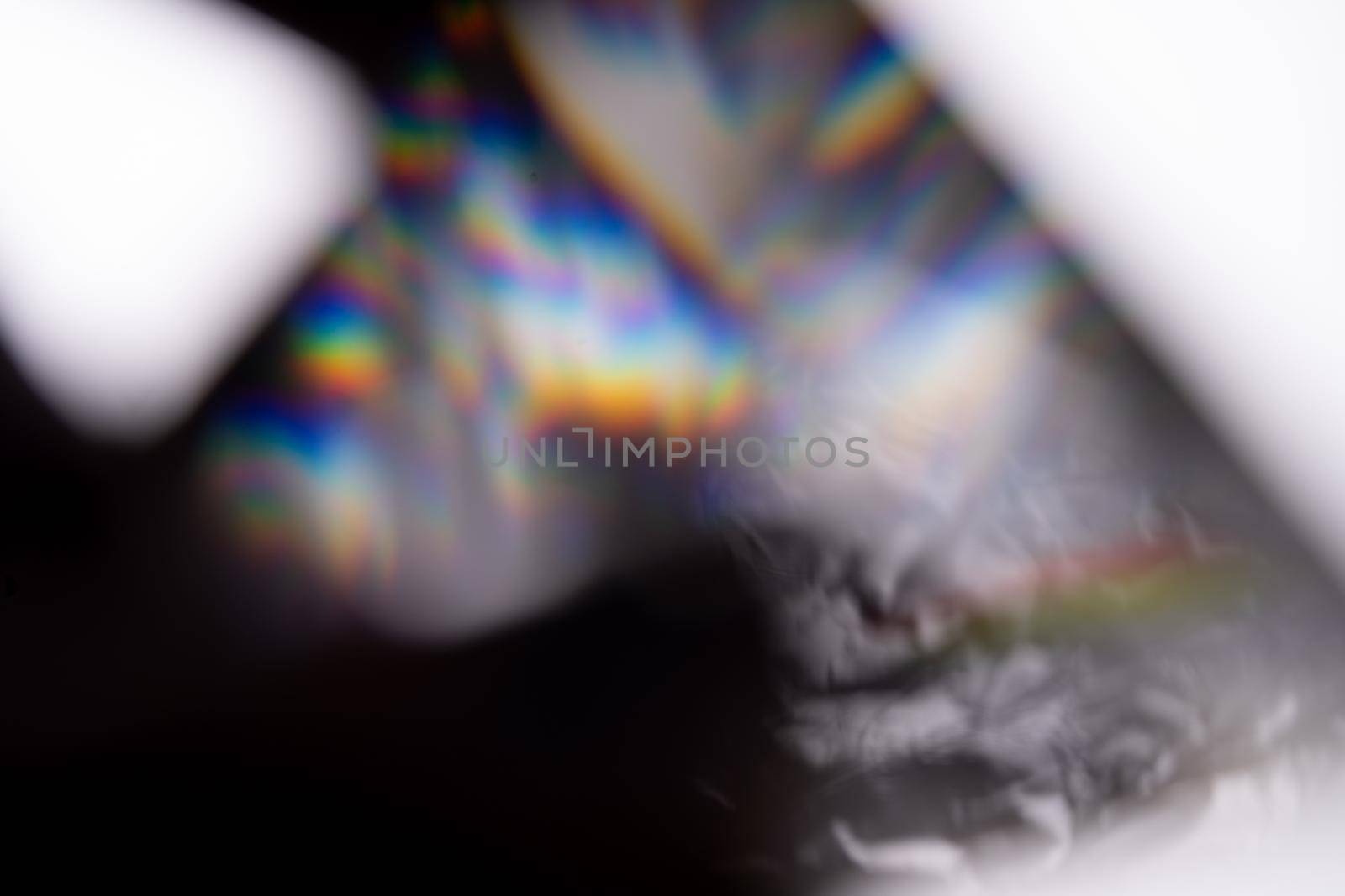 Blue light flare prism rainbow flares overlay effect on black background, light crossing crystals, prismatic sun catcher reflections rays. Abstract blurred colourful lens flare bokeh on dark by photolime