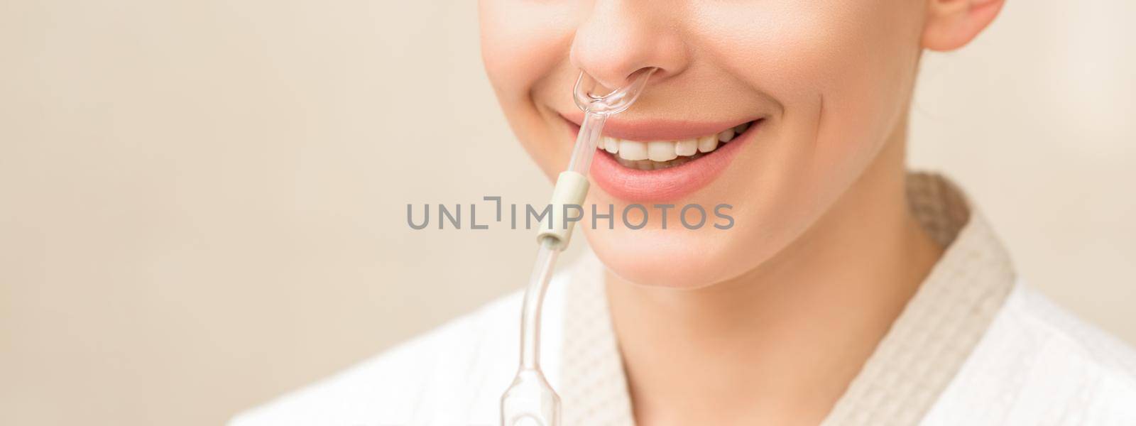 Beautiful happy young caucasian woman receiving nasal inhaler with essential oil smiling in a spa