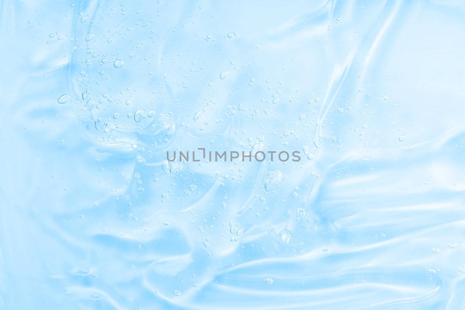 Liquid blue oil smudge. Hyaluronic acid clear serum sample. Aloe vera cosmetic gel texture with bubbles background. Skincare moisturizing product. Close-up, macro.