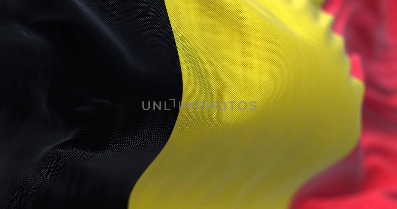 Close-up view of the belgian national flag waving in the wind. Belgium is a country in Northwestern Europe. Fabric textured background. Selective focus