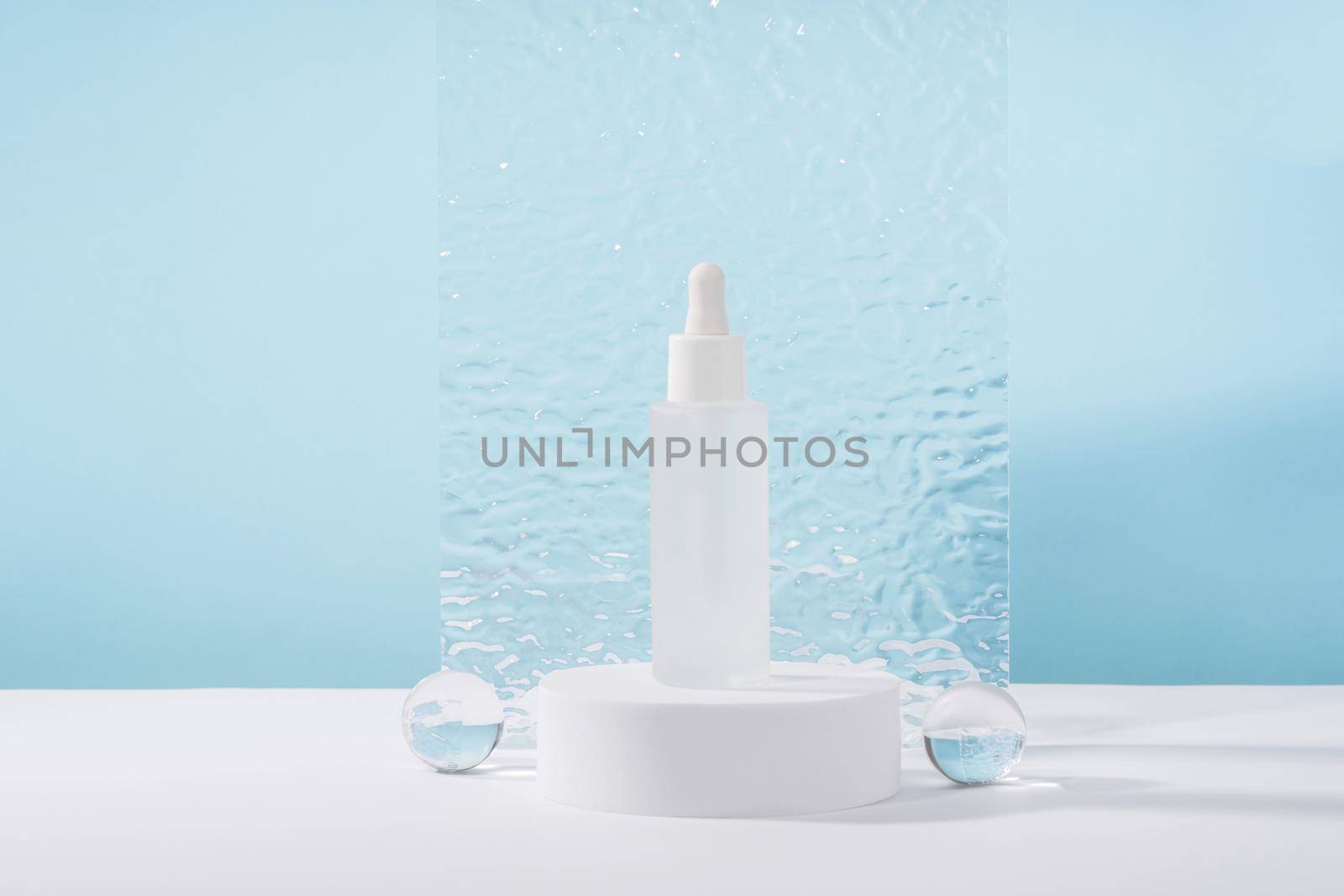 Unbranded cosmetic cream mockup on pedestal podium with stylish props, glass balls and acrylic plate. Lotion, concealer or white beauty product packaging. Product presentation mock up