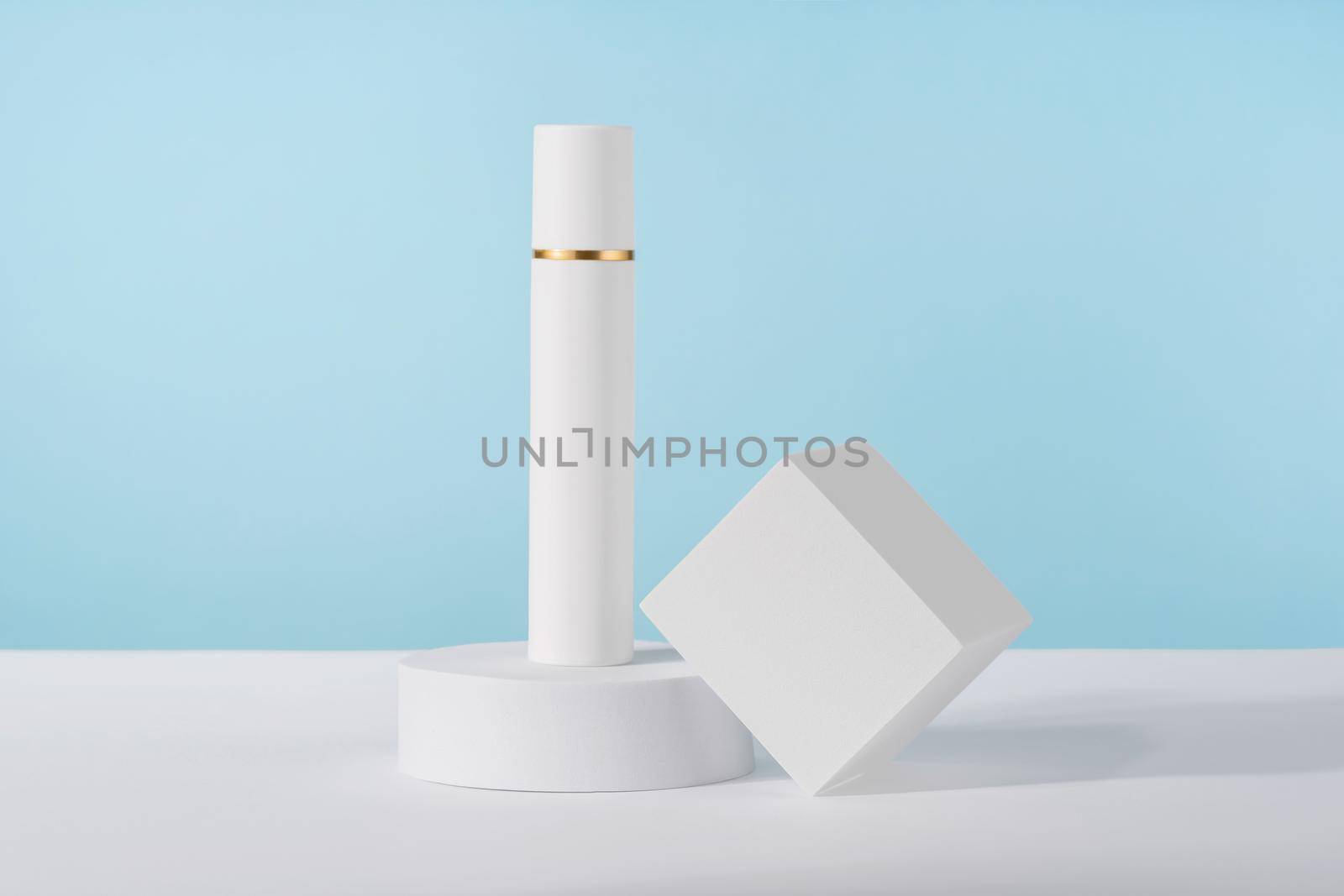 Cosmetic luxury cream bottle mockup on blue background on pedestal podium. Unbranded lotion beauty product packaging. Product presentation mock up. Lotion, cleanser for skincare routine by photolime