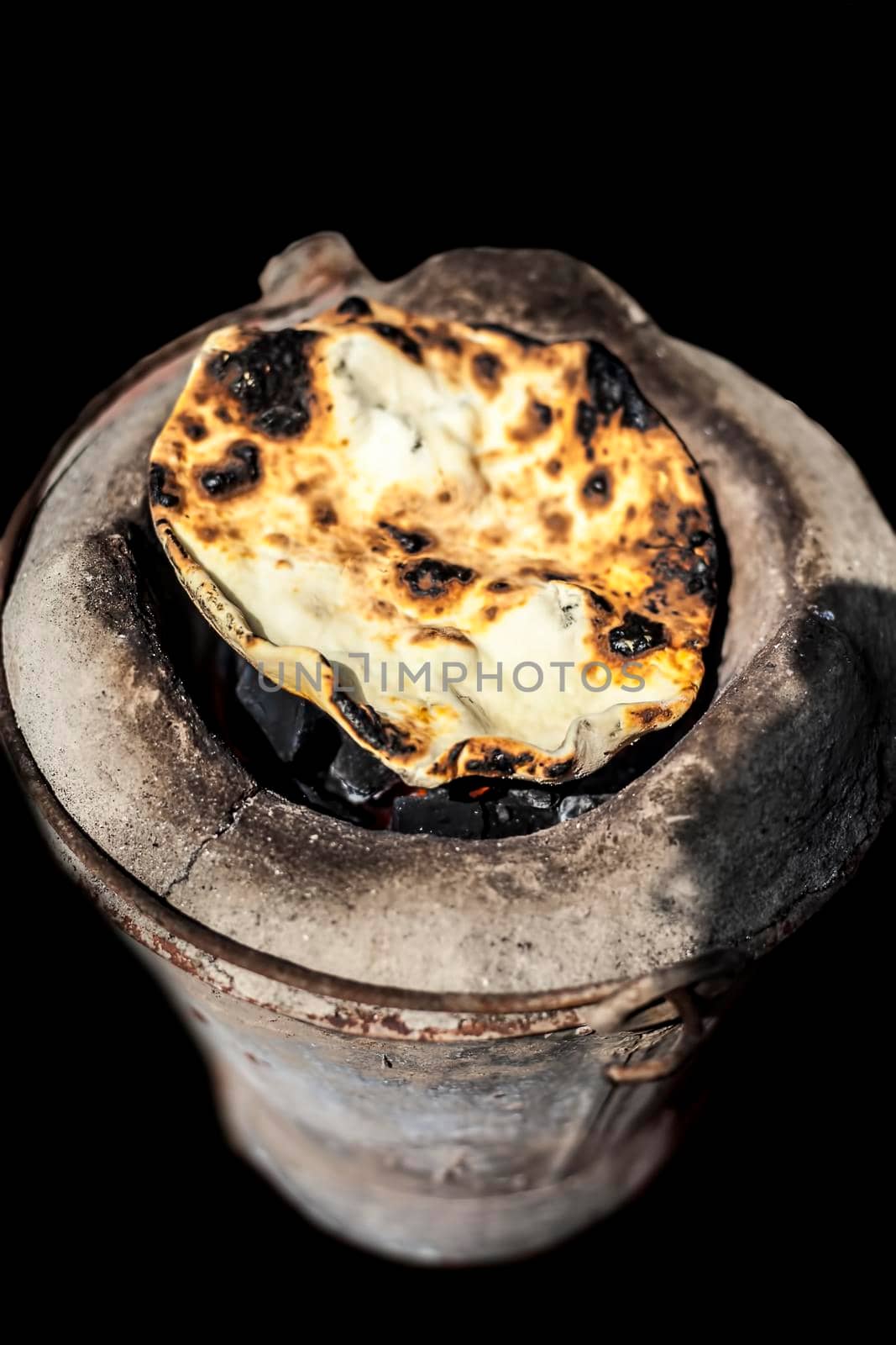 Shot of tandoori roti on old style cooking sigdi.