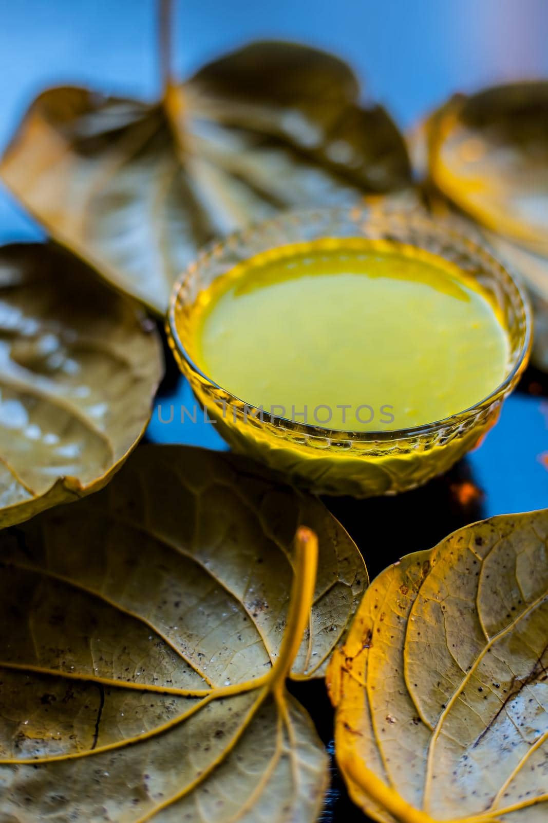 Face mask for preventing acne on a black wooden surface of betel leaves and turmeric powder. by mirzamlk