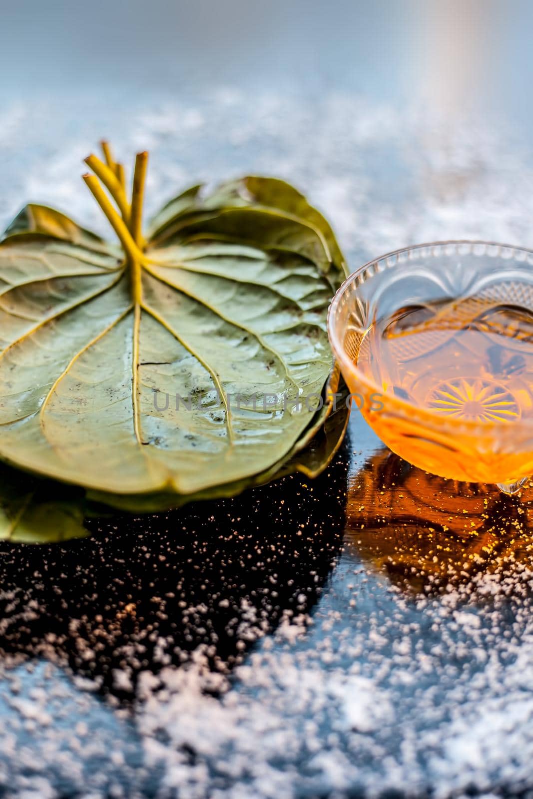 Face mask for controlling oiliness consisting of betel leaves, honey, sea-salt on a black wooden surface. by mirzamlk