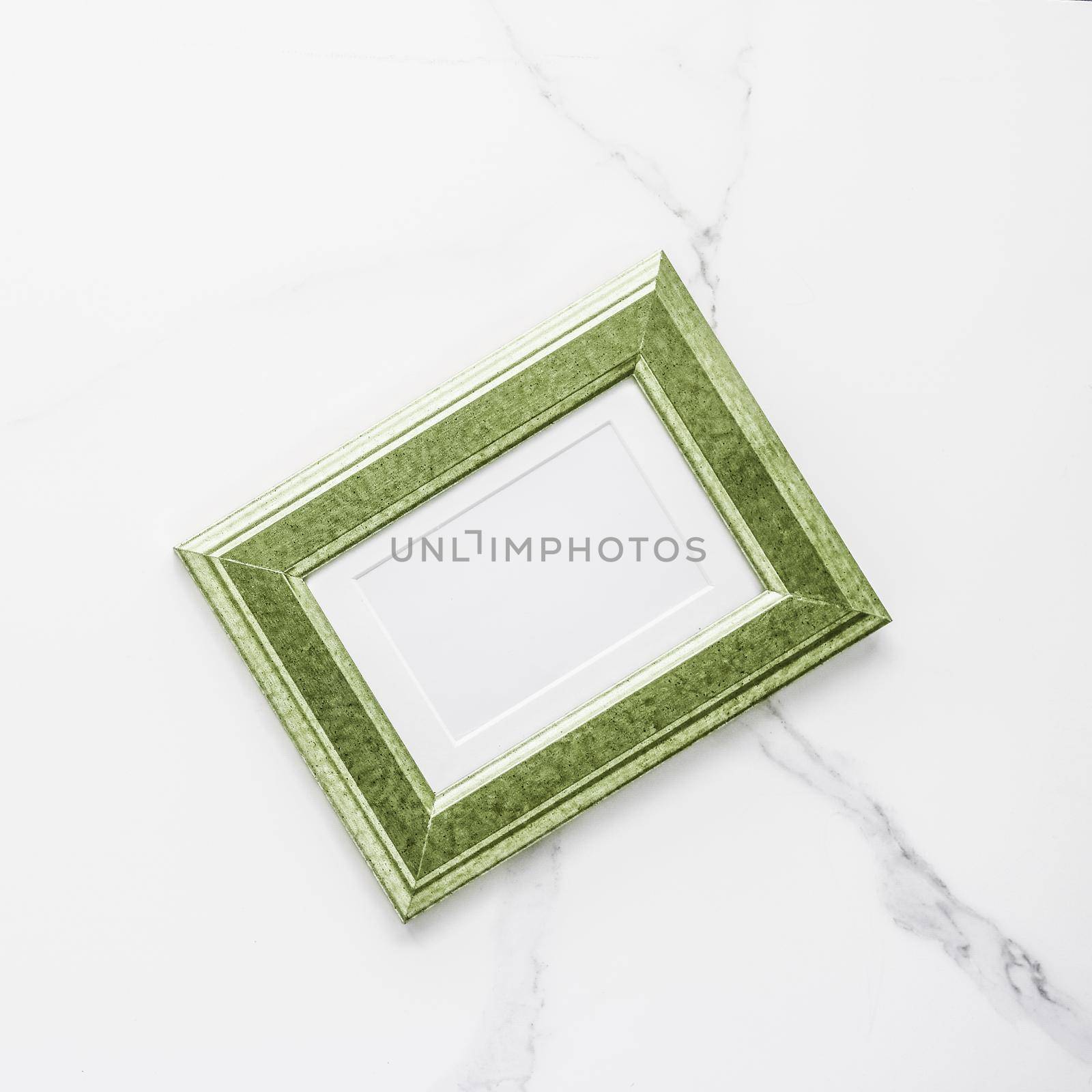 Green photo frame on marble, flatlay by Anneleven