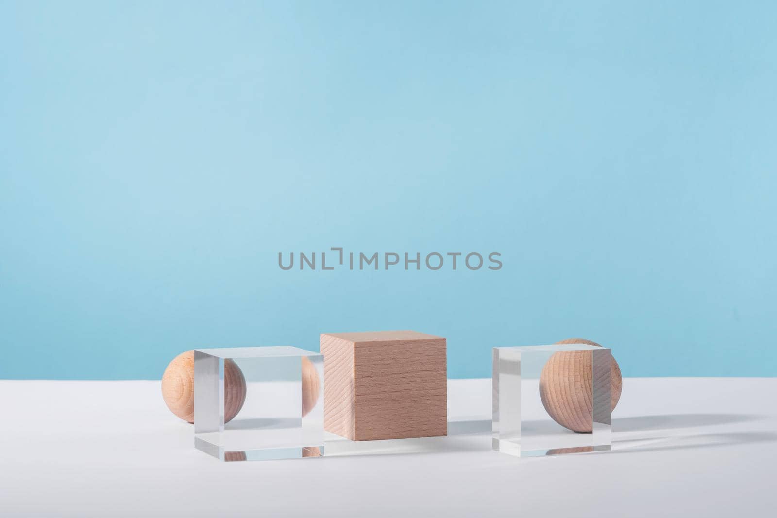 Creative geometric product stage mock up, cosmetic display platform, cosmetics showcase, geometric stand. Wooden and glass cube podium and sphere on blue background for product advertising by photolime