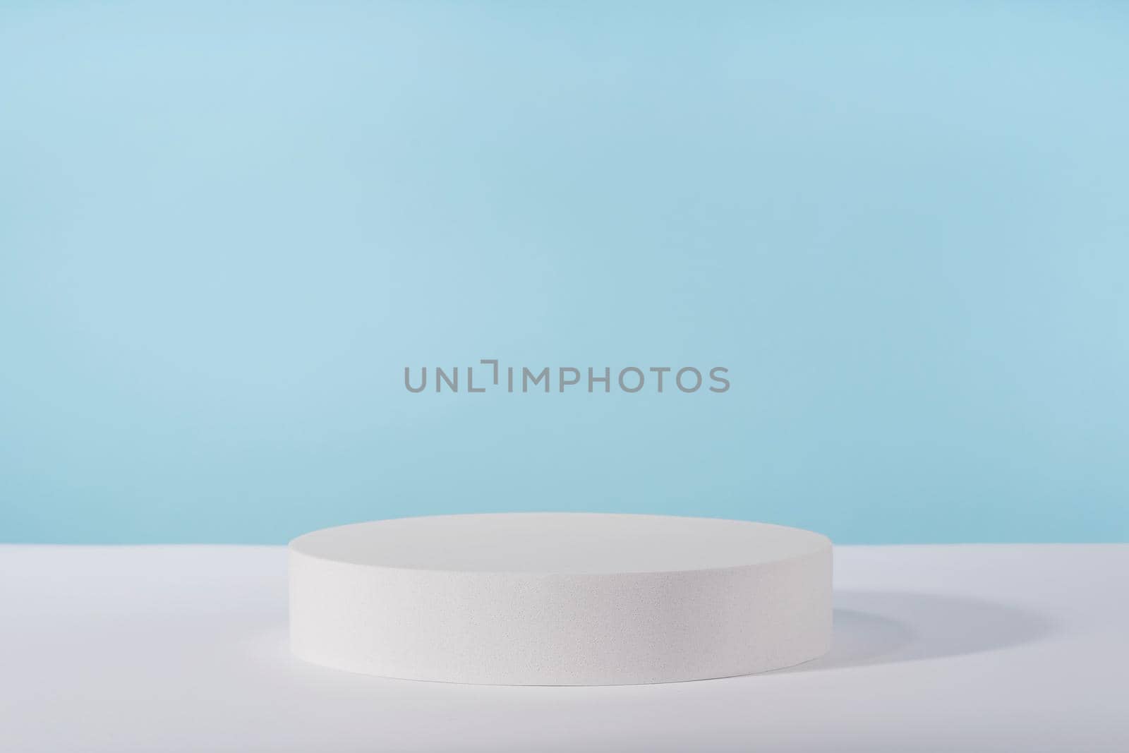 Podium pedestal for cosmetic product packaging on blue background. Showcase for jewellery presentation, white platform for perfume advertising, cosmetics stand background, branding scene by photolime