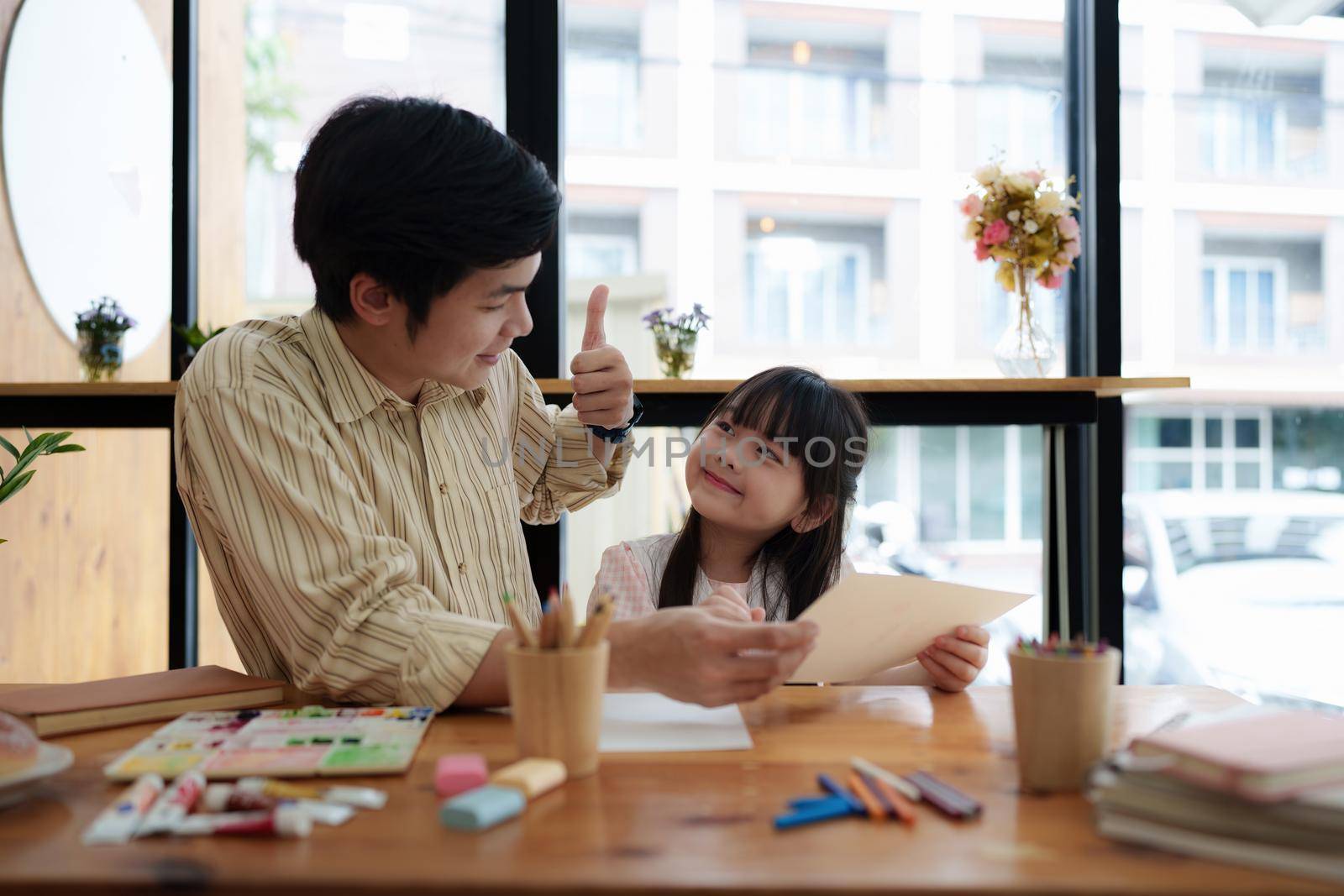 A happy kid and father painting at home. Handmade skills training by itchaznong