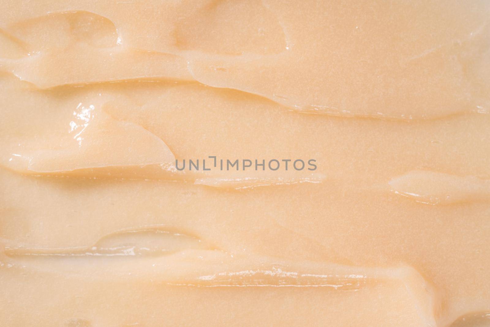 Hair conditioner cream background. Yellow cosmetic lotion moisturiser sample closeup. Body care balm, retinol serum, shampoo wavy texture. Skincare mask smear, creamy cleanser product swatch