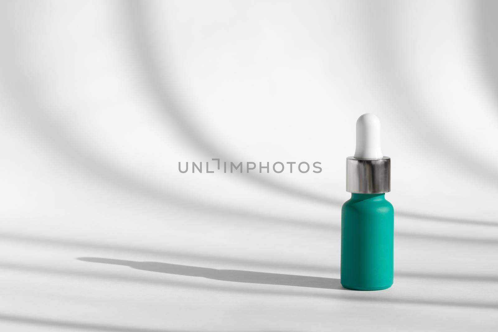 Anti aging serum with collagen, retinol and peptides on white with sunlight and shadow decor. Liquid essence product packaging bottle. Hyaluronic or polyglutamic acid oil cosmetic mockup. by photolime