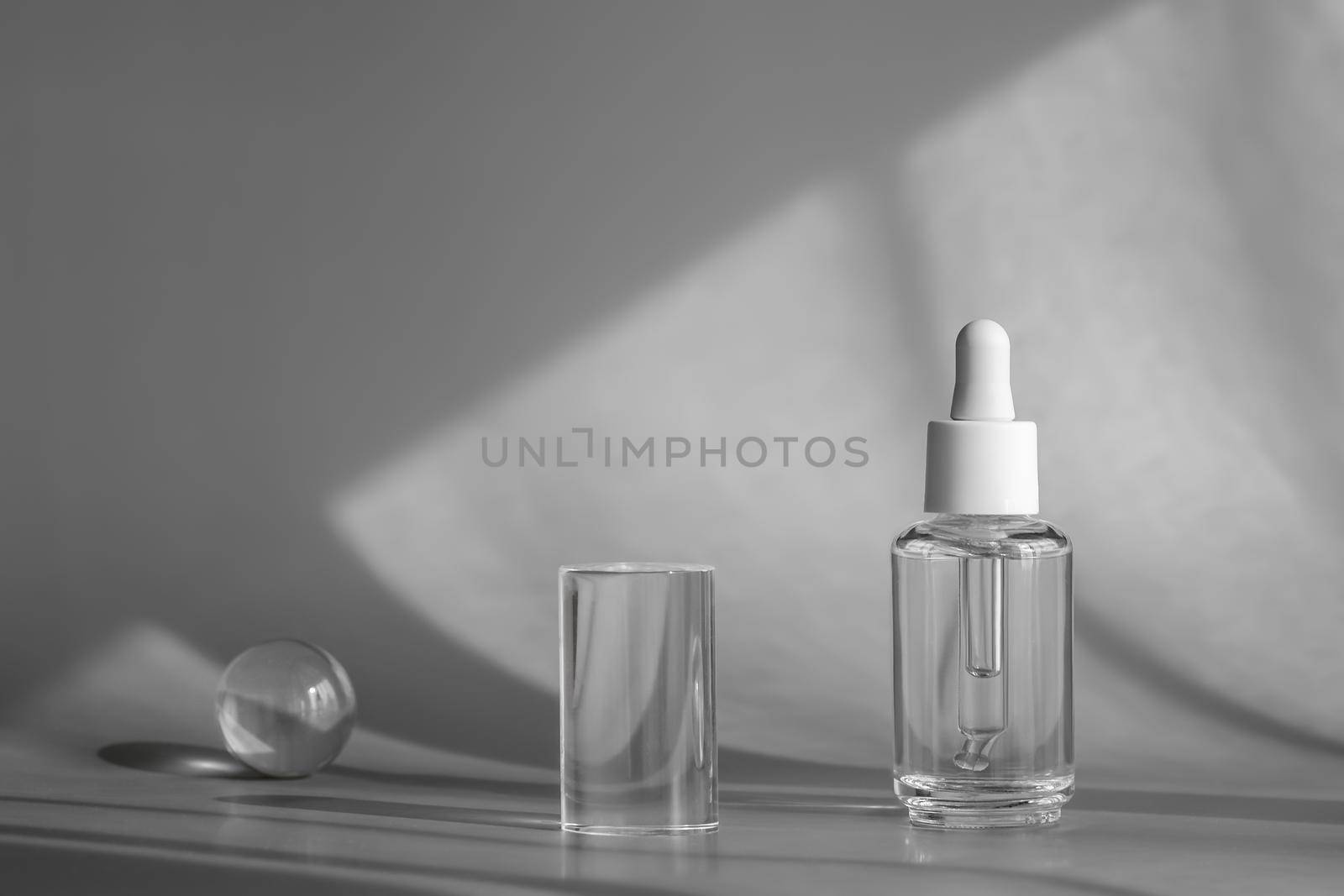 Glass cosmetic bottle, serum with peptides and retinol product packaging and modern acrylic transparent geometric shapes decor with shadows from sun, cosmetic mockup, skincare concept by photolime