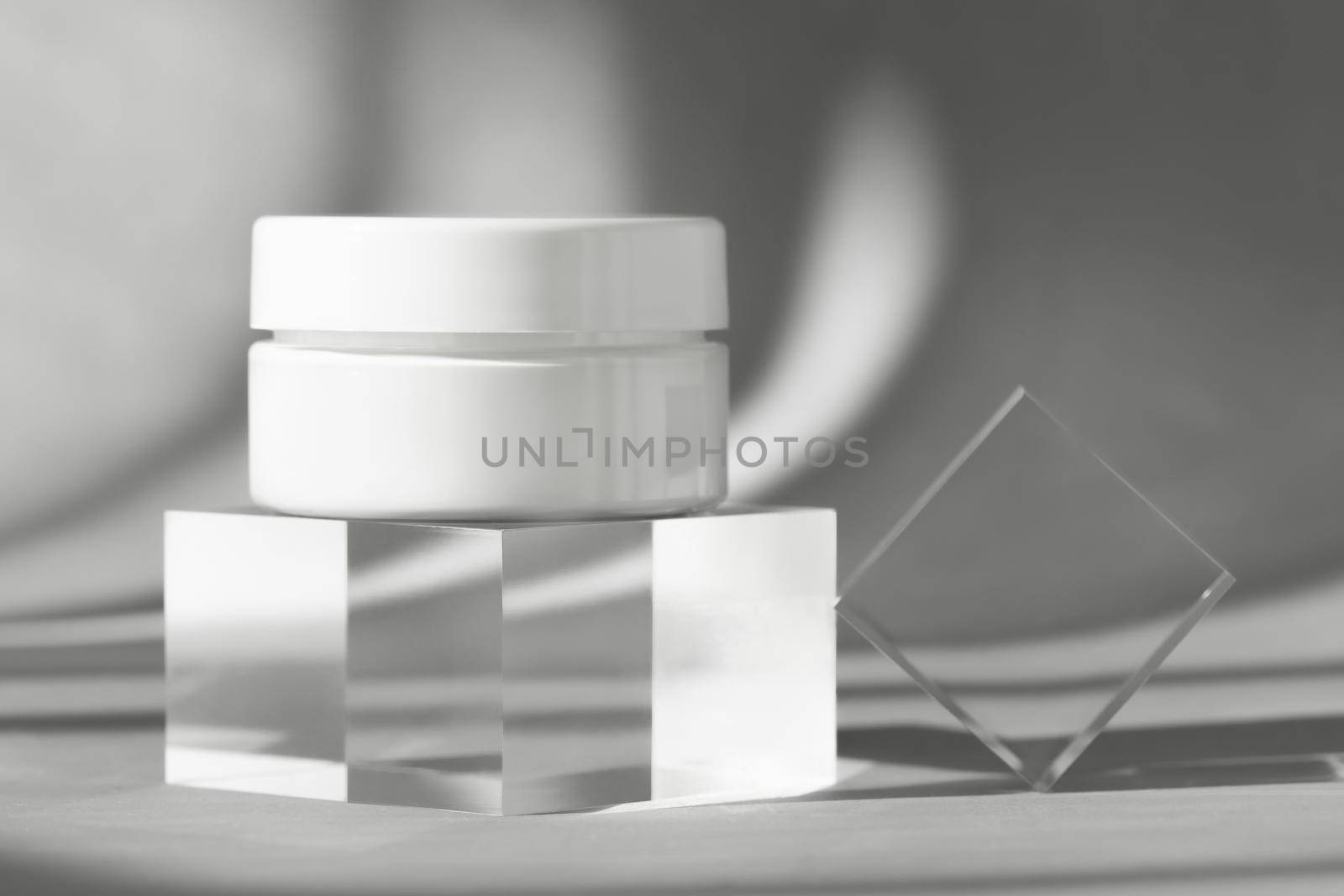 White cream cosmetic jar on acrylic geometric pedestal podium block, product packaging with shadows from windows, creme lotion cosmetics showcase presentation mockup. Front view