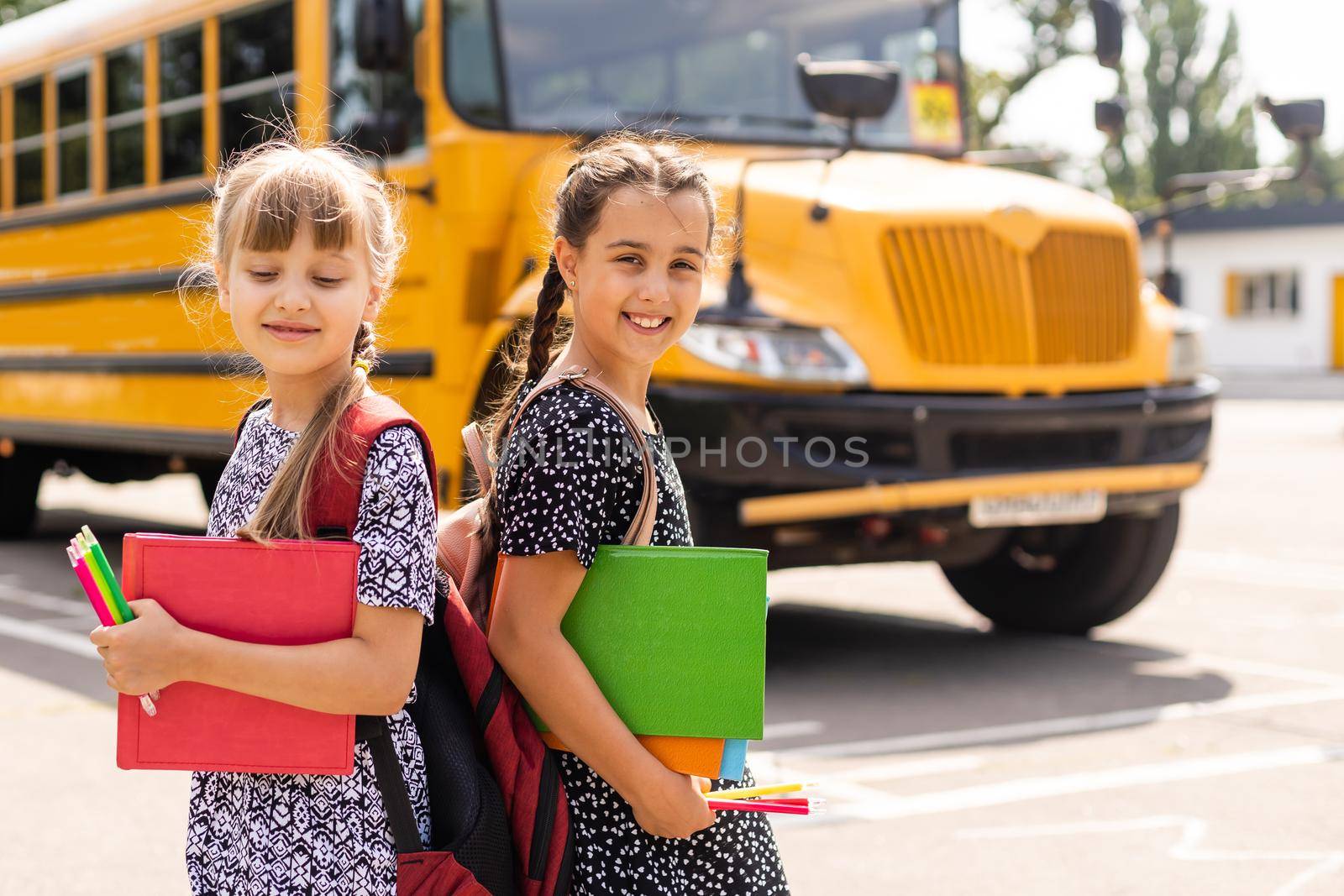 Education: Smiling Student Friends Ready For School next to school bus.
