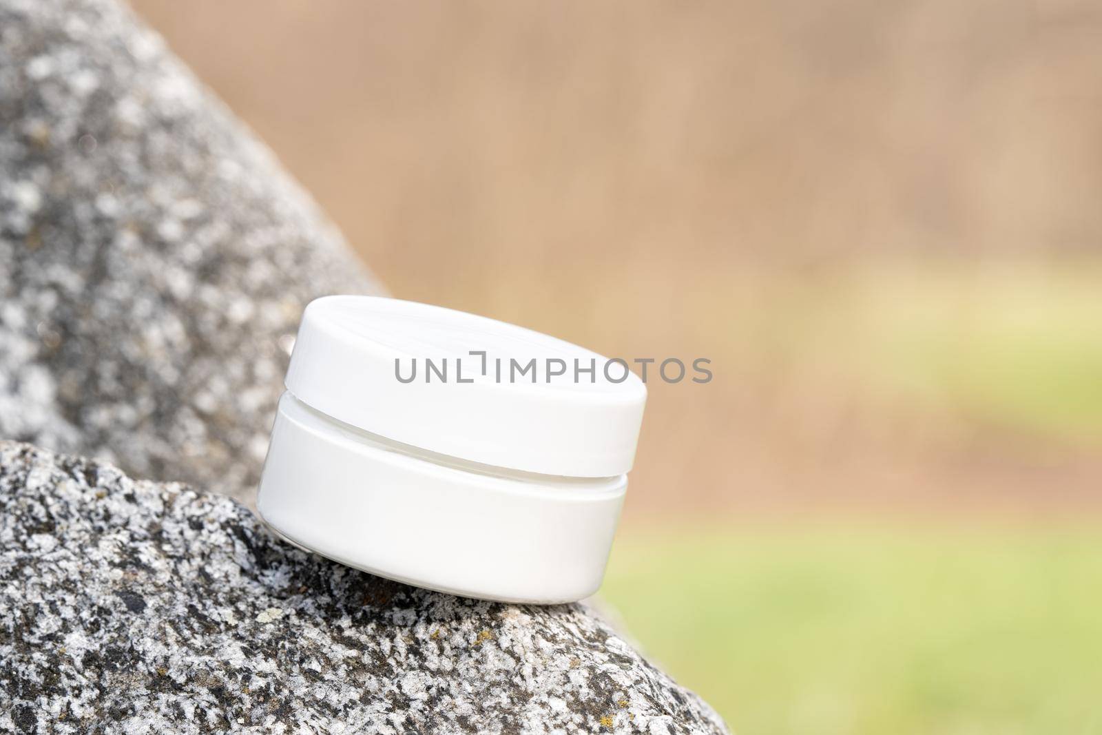Organic cosmetic product in jar. Beauty packaging mockup on stone natural background. Lotion, hand or eye cream for skincare routine. Front view, closeup. Cosmetics mockups for advertising design.