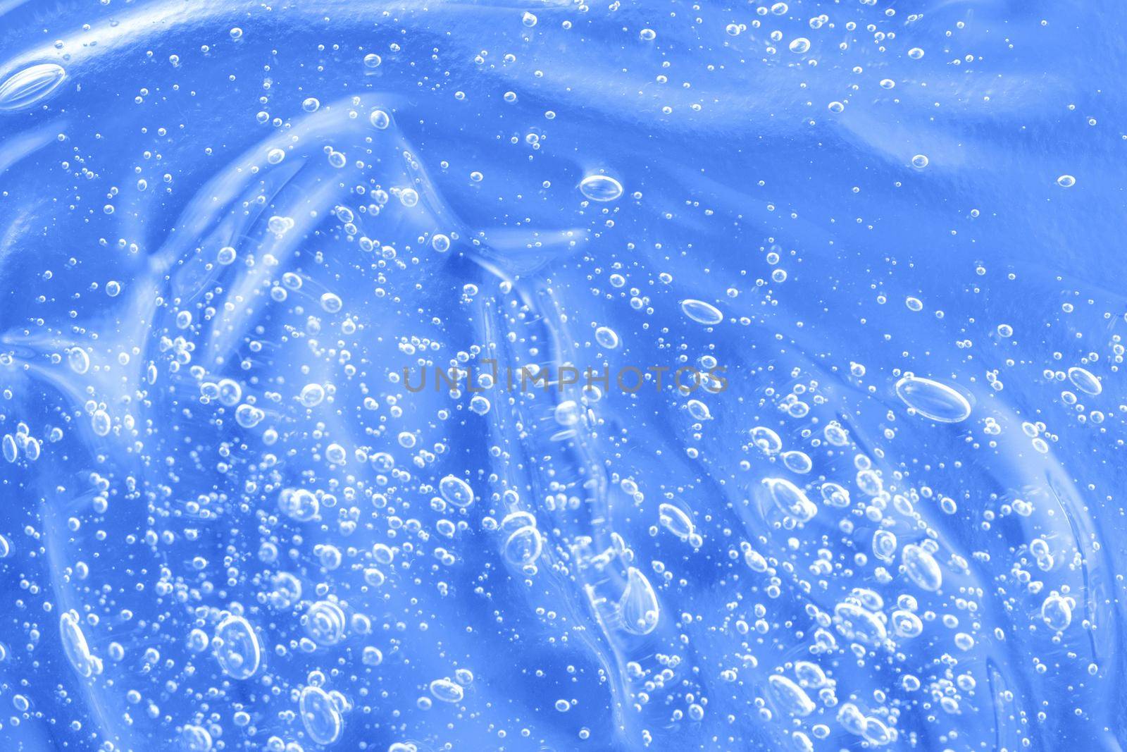 Liquid antibacterial disinfect smear smudge. Hyaluronic acid clear serum sample. Cosmetic blue gel texture with bubbles. Skincare moisturizing product background. Sanitizer swatch. Close-up, macro.