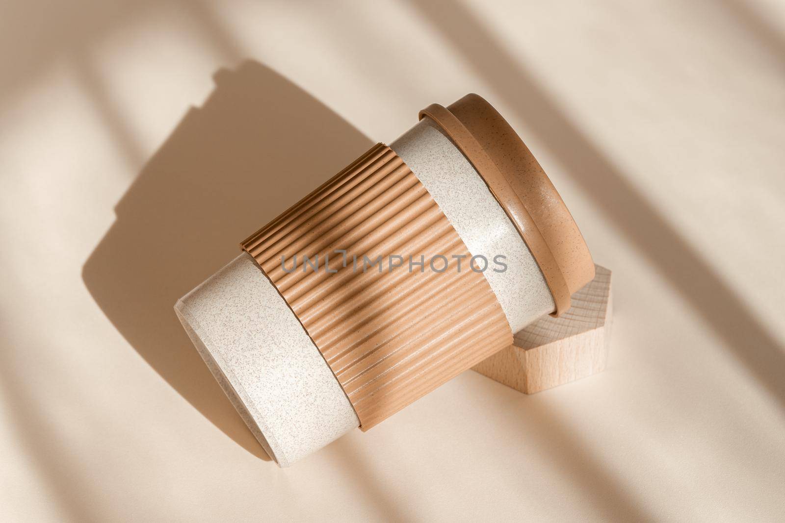 Bamboo eco friendly cup on natural shadow beige background. Reusable cup, biodegradable travel plastic coffee mug take away. Zero waste, sustainability concept. High angle view, sustainable by photolime