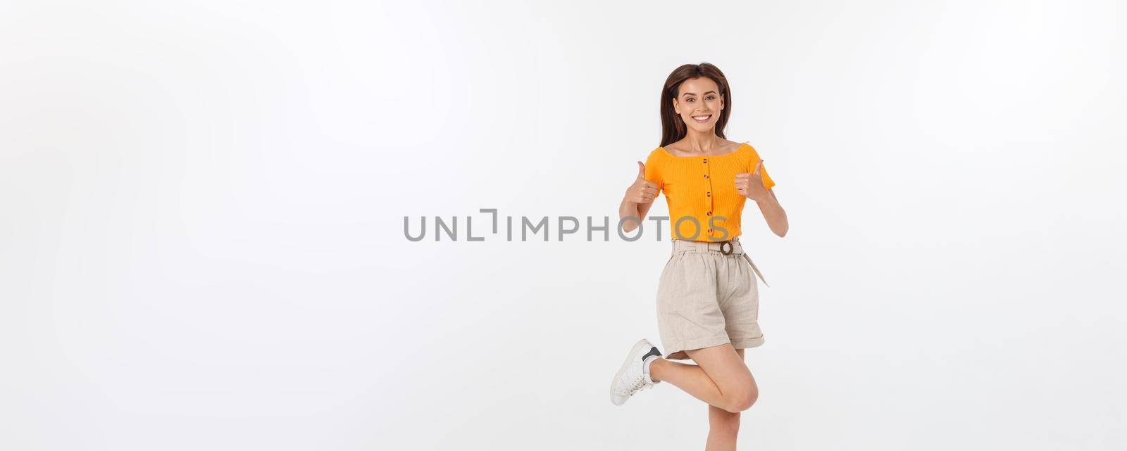 Portrait of a joyful woman jumping in the studio with happy feeling, isolated on white background, 20-28 year old