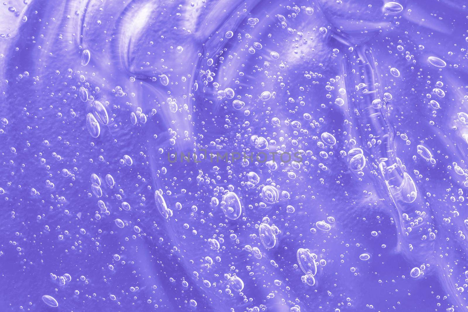 Skincare moisturizing product background. Liquid antibacterial disinfect smear smudge. Cosmetic lilac gel texture with bubbles. Hyaluronic acid clear serum sample. Sanitizer swatch. Close-up, macro.