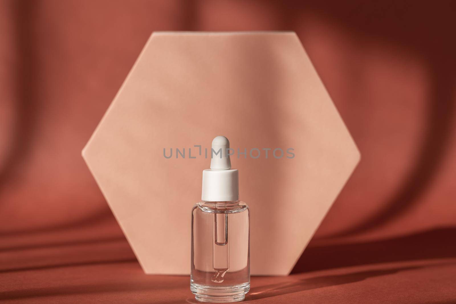 Hyaluronic acid, serum skincare bottle on beige podium pedestal. Serum product cosmetic with peptide and collagen on brown surface. Modern brand packaging with shadows. by photolime