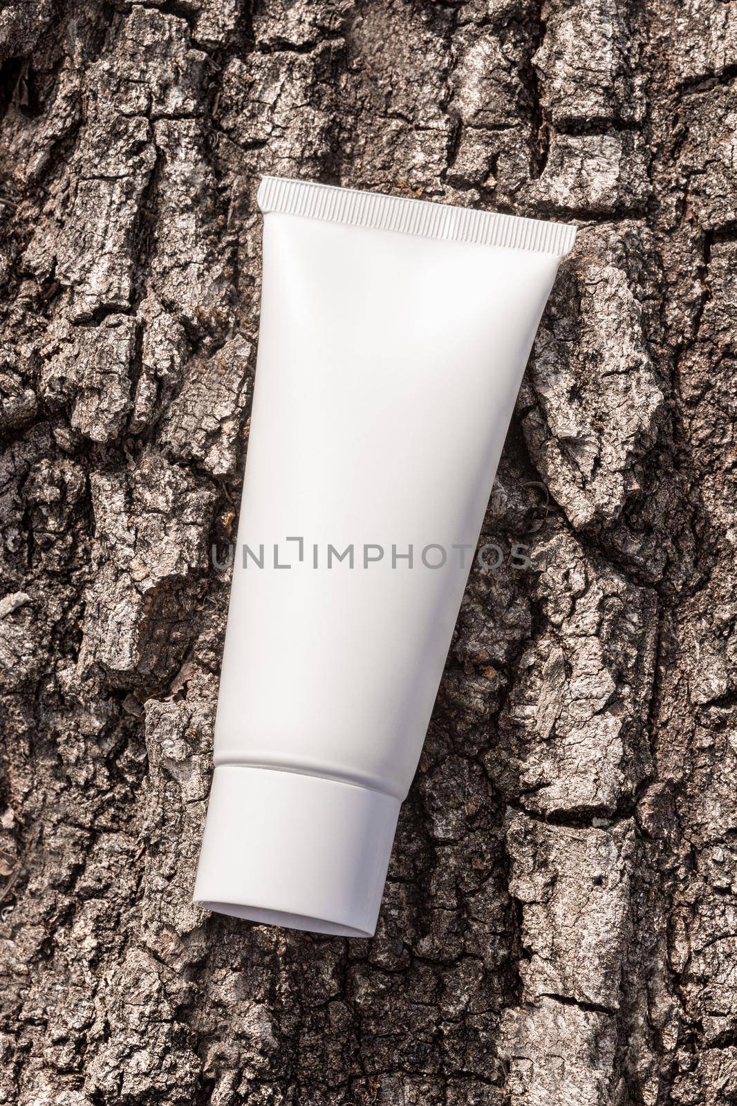 Beauty product packaging mockup. Organic cosmetic cream in tube on a tree bark natural background. Cream bottle, lotion, shampoo for skincare routine. by photolime