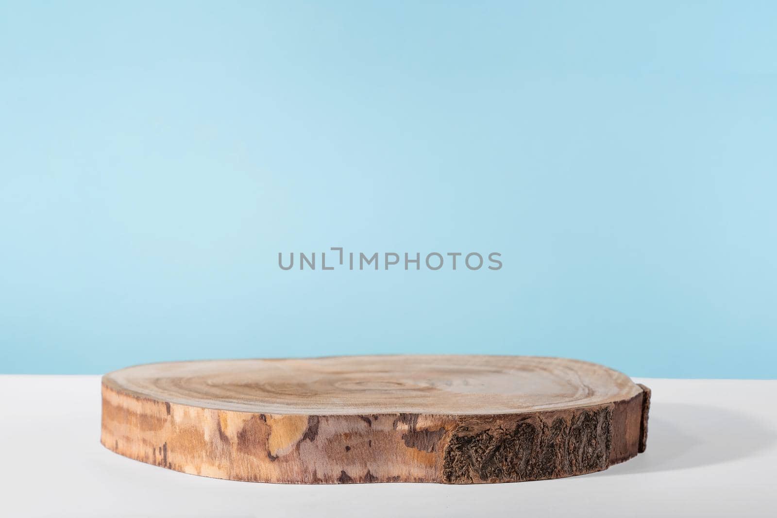 Background for cosmetic product presentation, wooden podium showcase on blue background for cosmetics perfume and jewellery minimalist display. Empty stage pedestal for beauty products by photolime