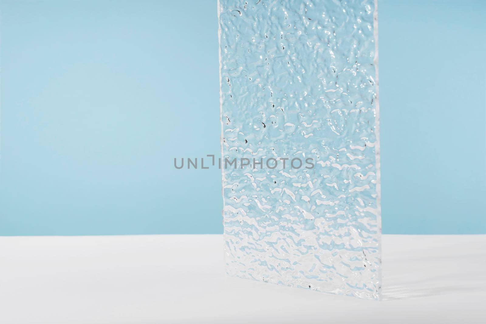 Acrylic ribbed plate, background for cosmetic product packaging on blue backdrop. Showcase for jewellery presentation, display for perfume advertising, cosmetics stand minimal branding scene by photolime