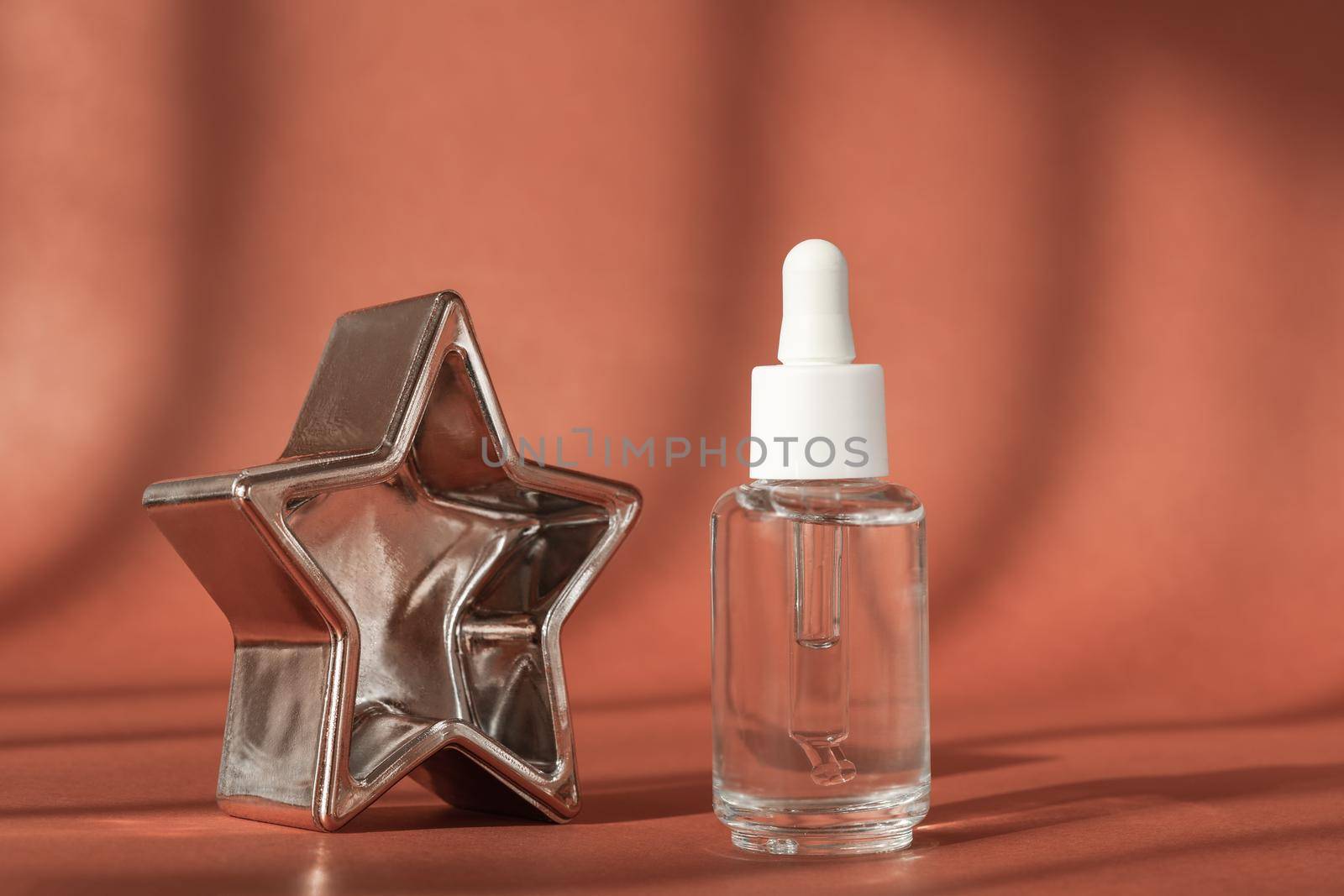 Serum cosmetic bottle, hyaluronic acid on brown background. Serum with peptide and collagen cosmetics. Cosmetic showcase, natural shadows. Commercial modern brand packaging mockup. by photolime