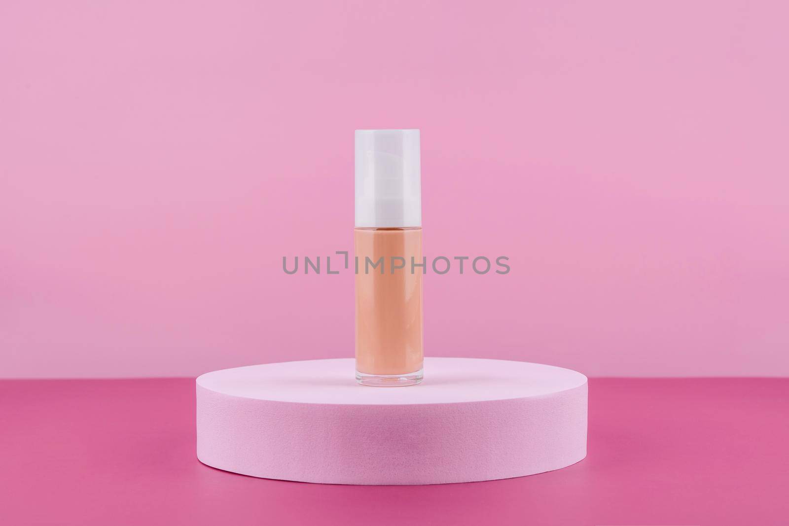 Cosmetic liquid foundation nude cream bottle mockup on round podium pedestal. Beige concealer base cosmetics product mock up on pink background. Skincare beauty primer, bb cc corrector