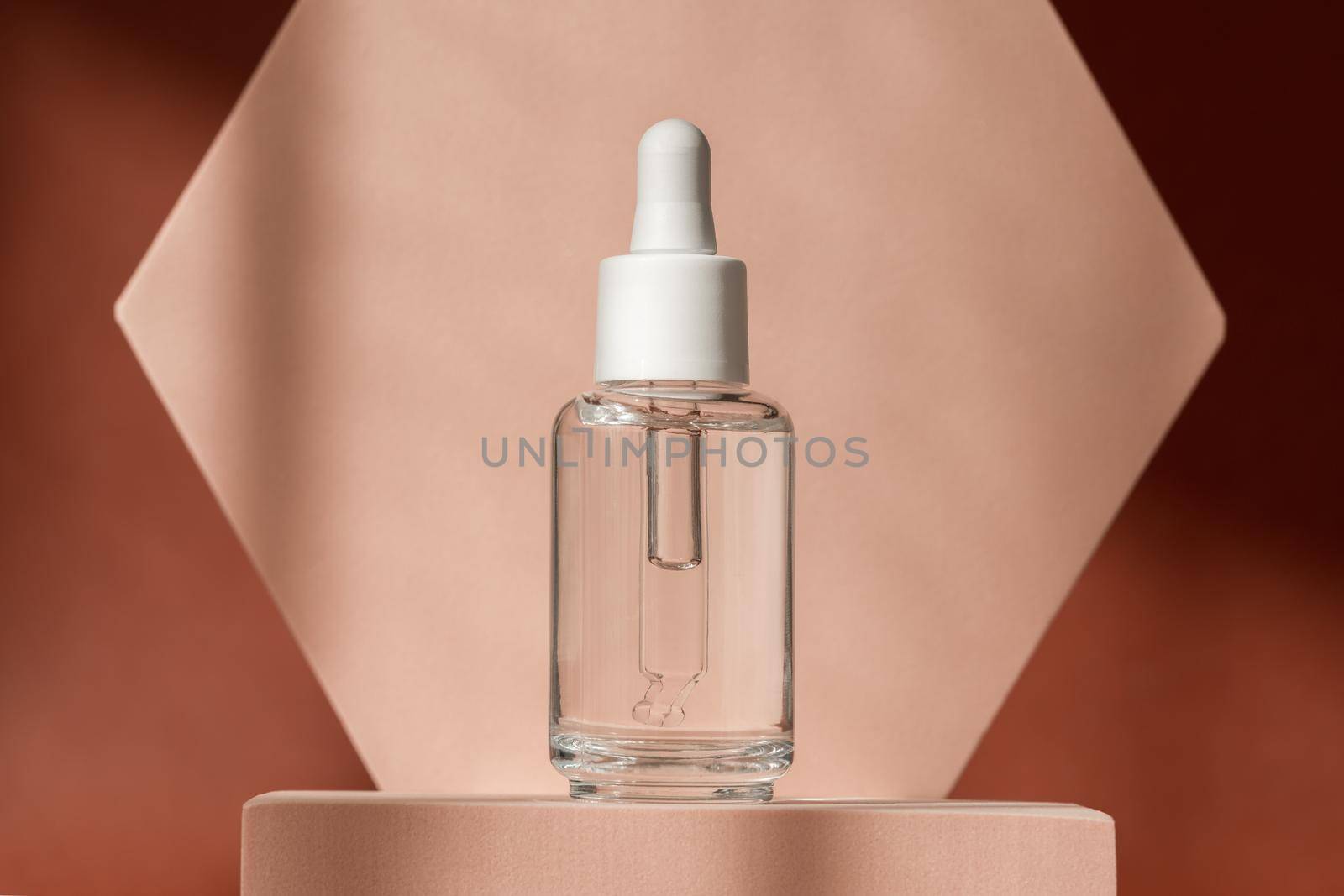 Hyaluronic acid, serum skincare bottle on beige podium pedestal. Cosmetics organic serum product with peptide and collagen on brown surface. Modern brand packaging with shadows. Cosmetic showcase