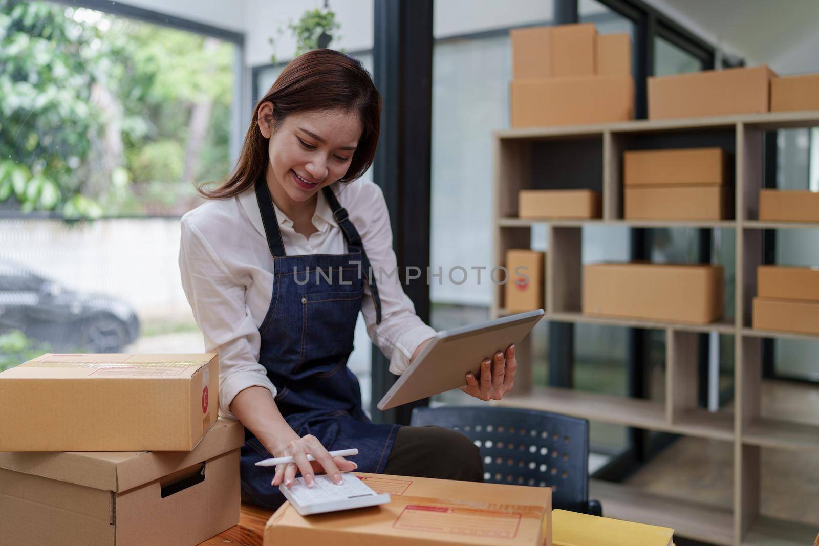 Asian SME business woman working at home office. online shopping concept.