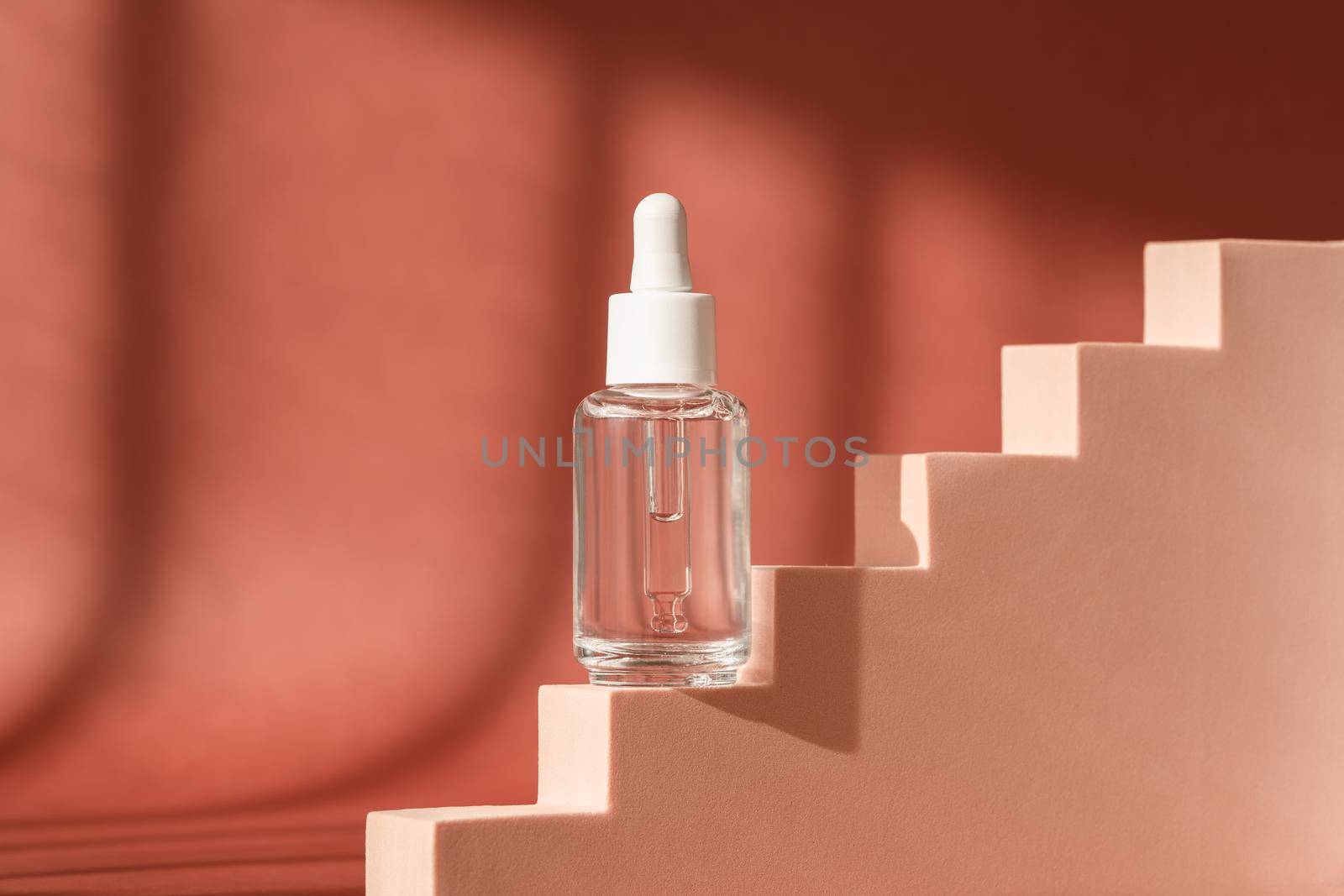 Serum skincare glass bottle, hyaluronic acid on brown podium pedestal, art deco. Serum product cosmetic with peptide and collagen. Modern brand cosmetics packaging. Cosmetic showcase by photolime