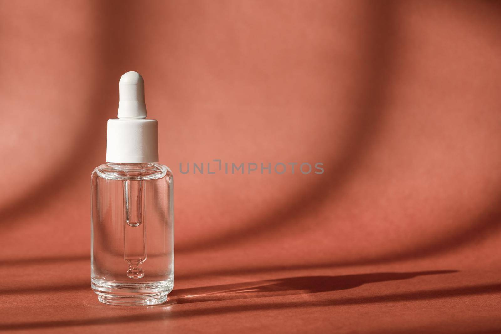 Serum cosmetic bottle, hyaluronic acid on brown background. Serum product cosmetic with peptide and collagen, modern brand glass cosmetics packaging. Cosmetic showcase by photolime