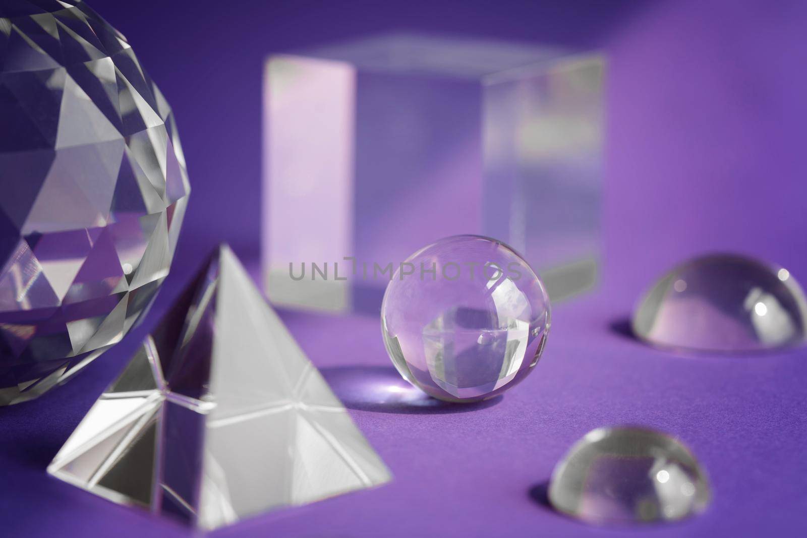 Crystal prism refracting light, magic crystals and pyramid, sphere and cube on purple background. Spiritual healing crystal practice. Feng Shui, good energy flow concept background.. by photolime