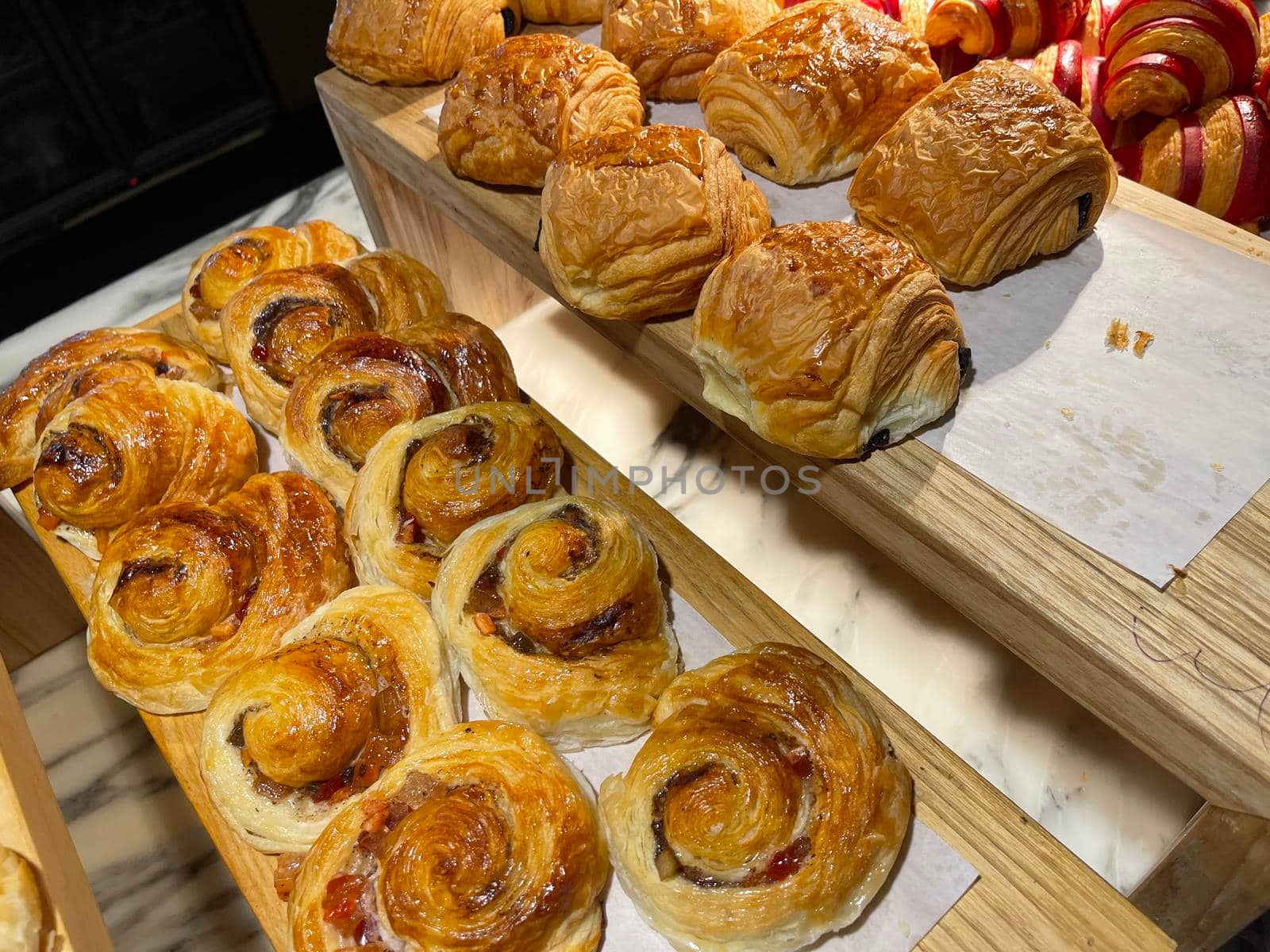 Lines of fresh baked cinamon rolls, super delicious cinamon rolls, French and American Croissants and baked cinamon rolls are enjoyed world wide on bakery shop, tasty multiple baked cinamon rolls