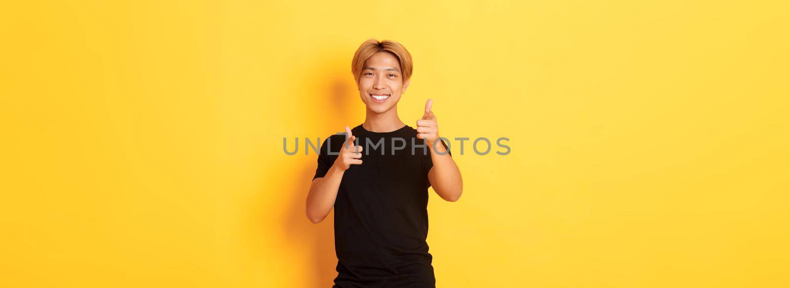 Portrait of cheeky smiling asian guy, looking satisfied and pointing fingers at camera, praising something or making compliment by Benzoix