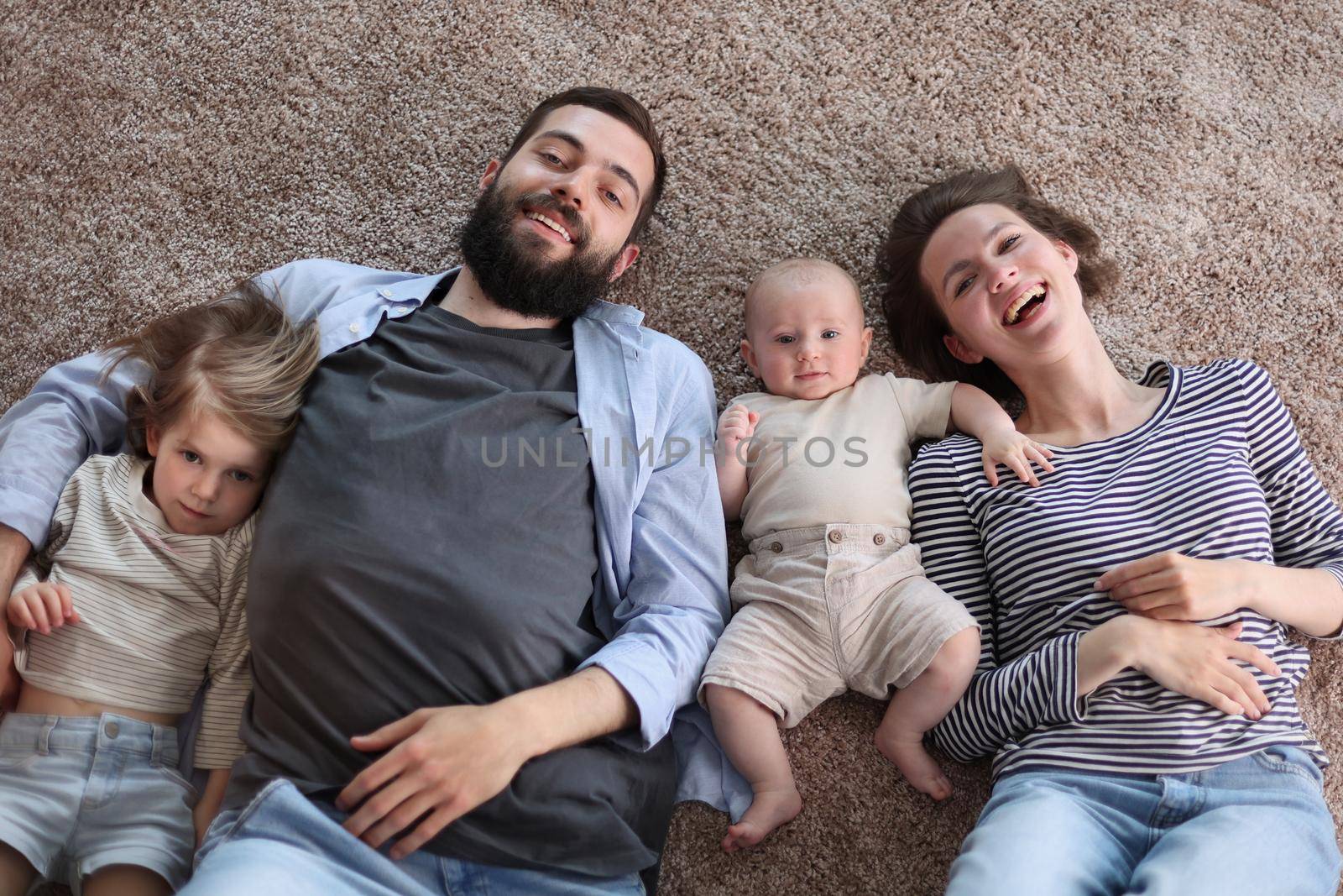happy family mother father and kids at home. laying