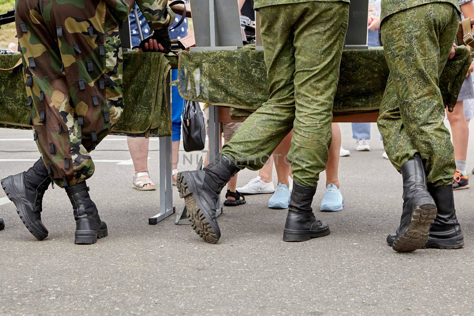 the military stand in camouflage with their backs in boots. feet of dirty soldiers
