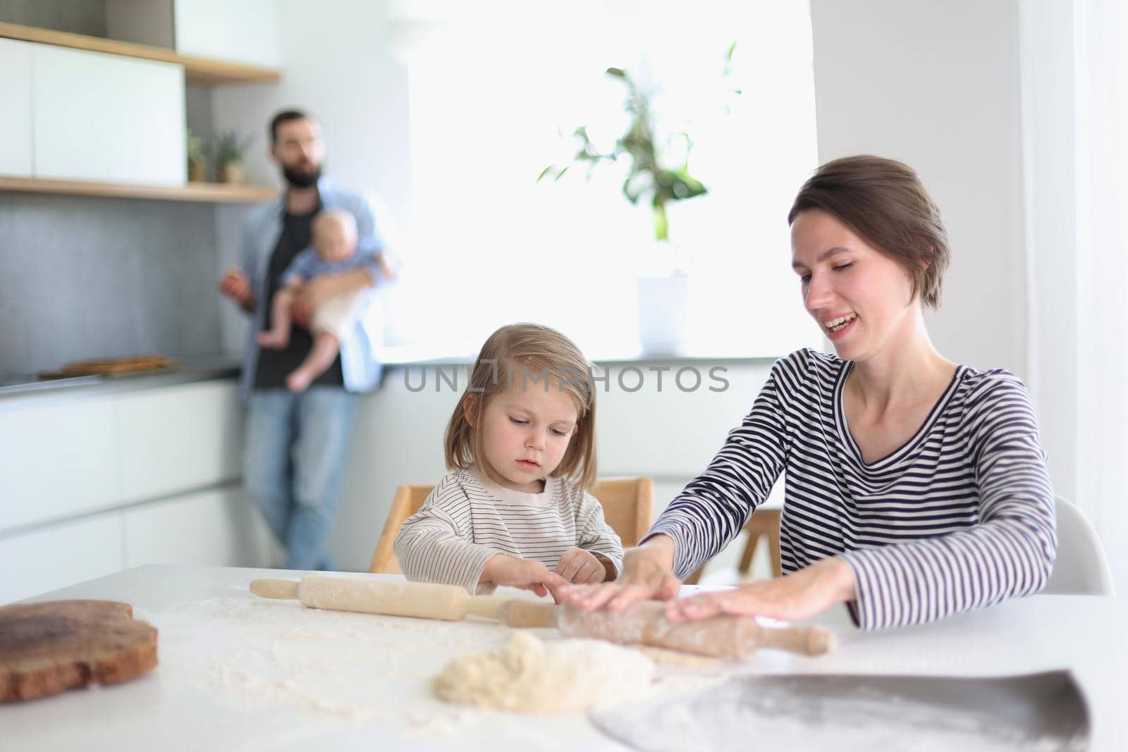 Happy parents playing with their children in the kitchen