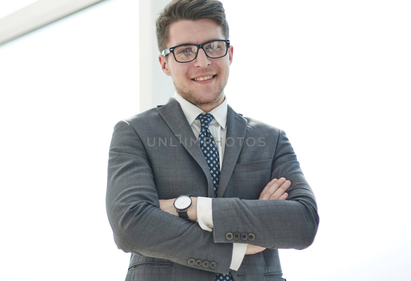 Portrait of a young businessman wearing glasses and standing in office