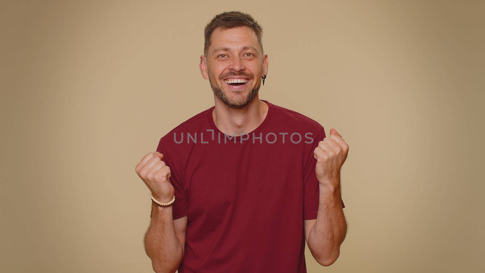 Oh my God, Wow. Excited amazed man looking surprised at camera with big eyes, shocked by sudden victory game winning, lottery goal achievemen, good news. Adult guy on beige studio background indoor