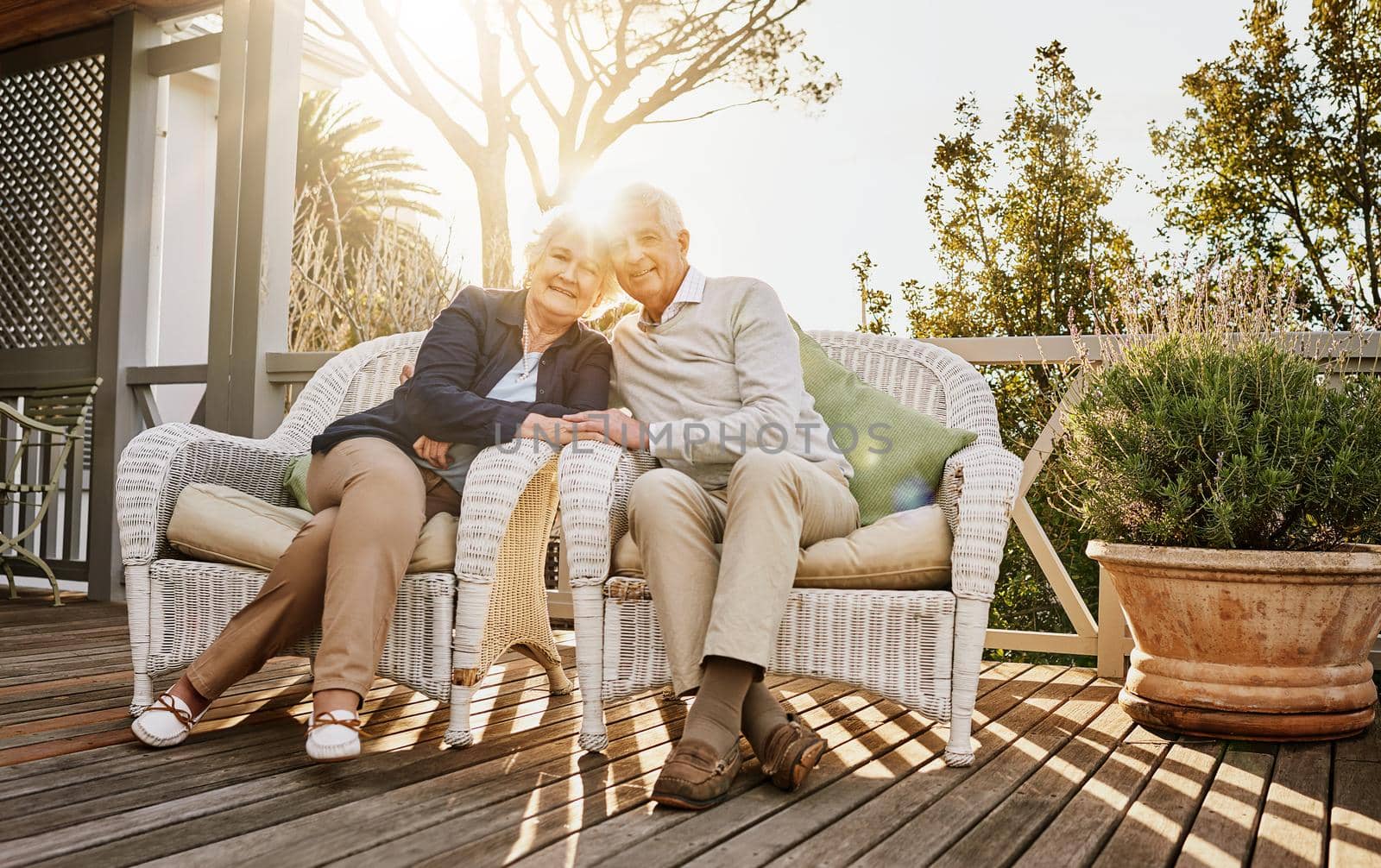 And now to relax. a happy senior couple relaxing together on the patio at home. by YuriArcurs