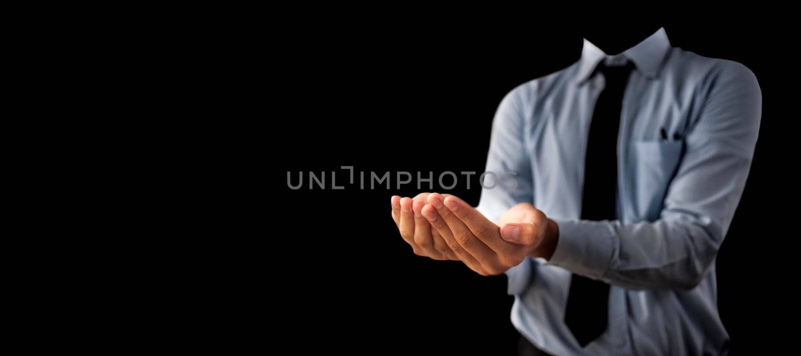 Shot of a unrecognizable man wearing blue shirt black tie and hands in a shape containing something inside it isolated on black background. by mirzamlk