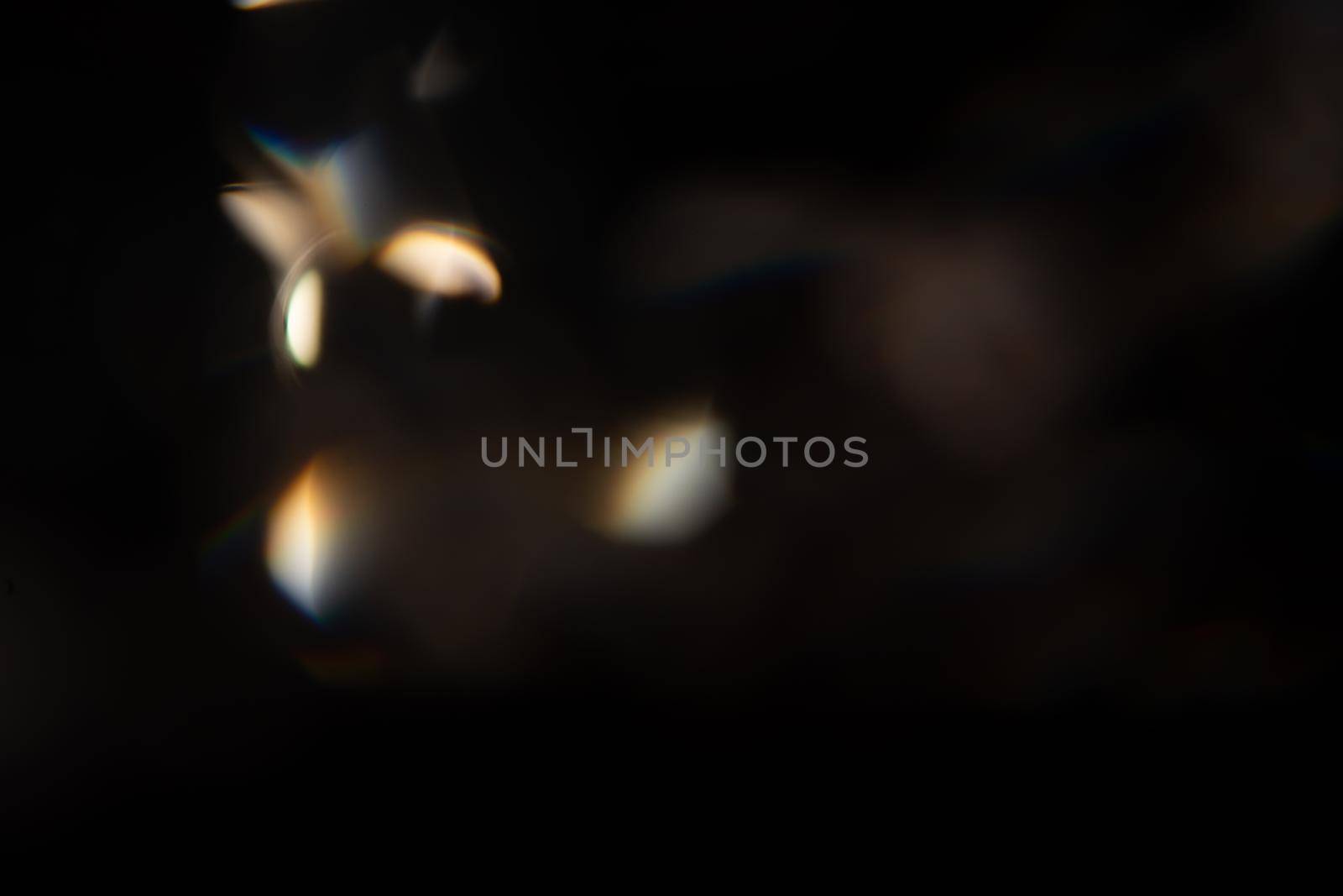 Blue light flare prism rainbow flares overlay effect on black background, light crossing crystals, prismatic sun catcher reflections rays. Abstract blurred colourful lens flare bokeh on dark by photolime