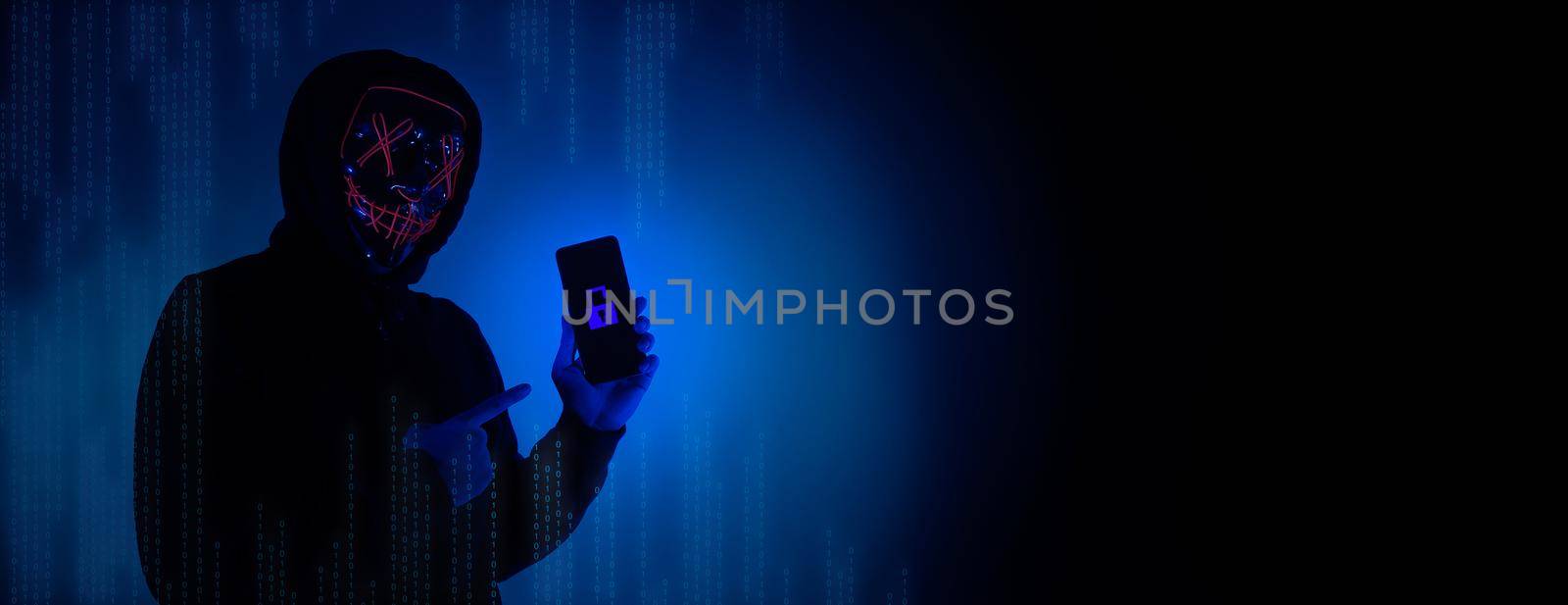 Digital security Concept. Anonymous hacker with mask holding smartphone hacked. by gnepphoto