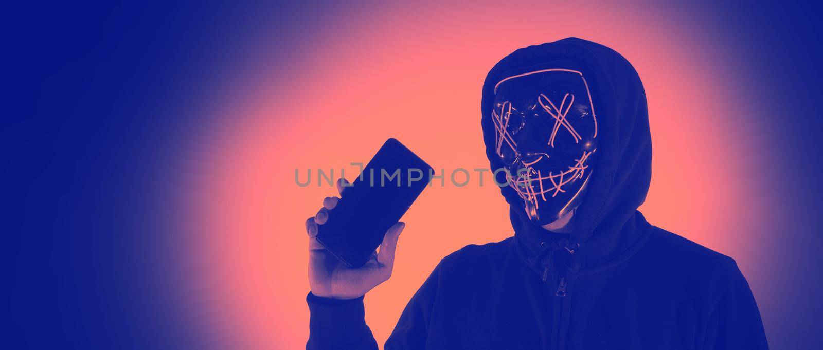 Digital security Concept. Anonymous hacker with mask holding smartphone hacked. Personal and Cyber data security in mobile phone stolen by man in mask. Represent digital privacy protection concept.