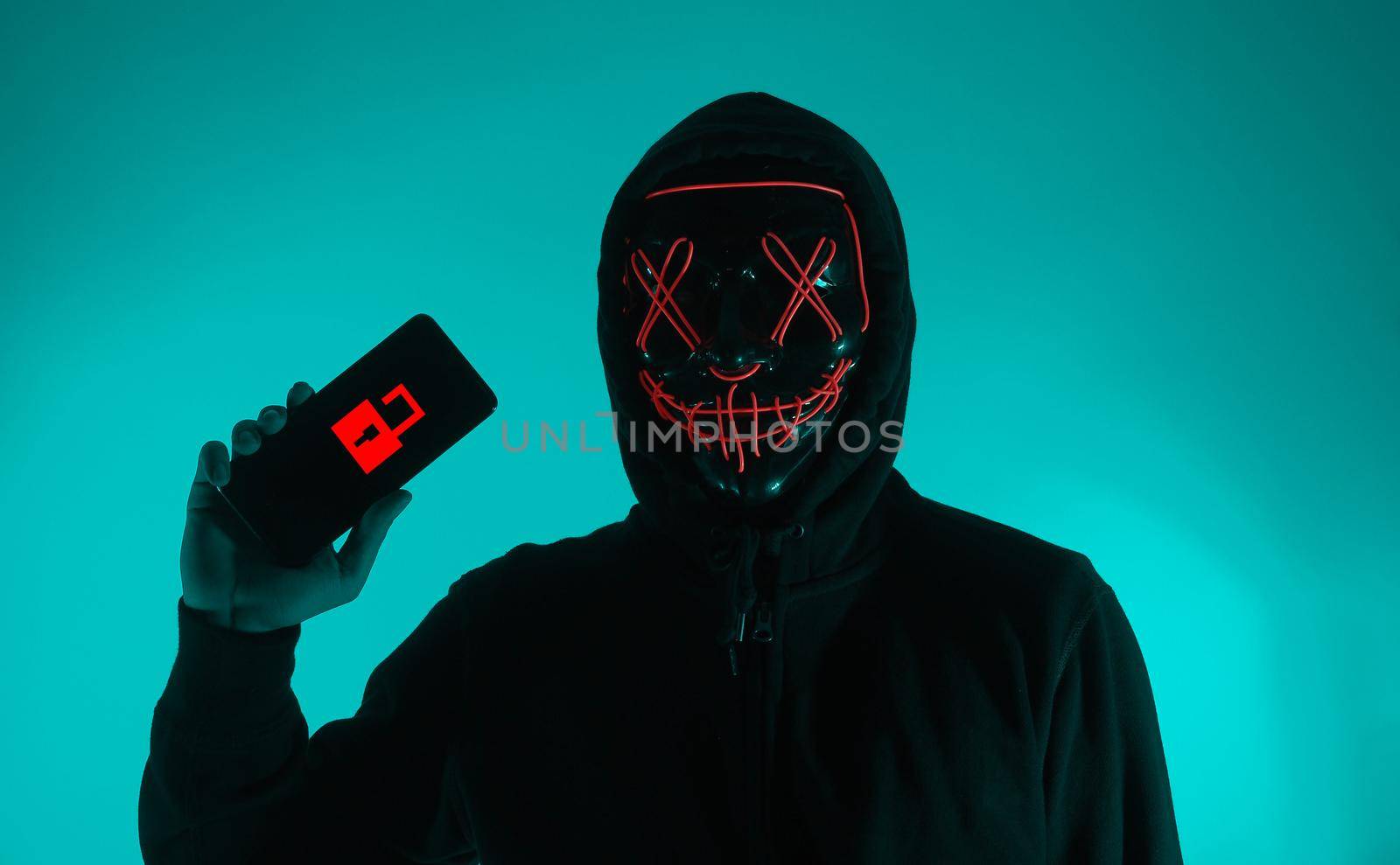 Digital security Concept. Anonymous hacker with mask holding smartphone hacked. Personal and Cyber data security in mobile phone stolen by man in mask. Represent digital privacy protection concept.