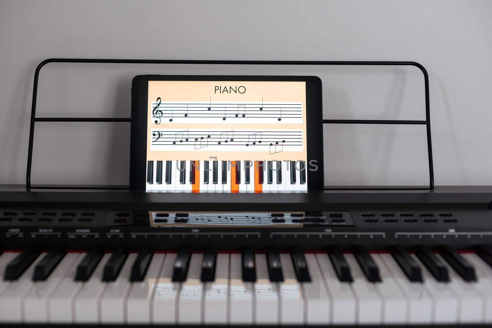 Piano synthesizer app on tablet and musical instrument concept.