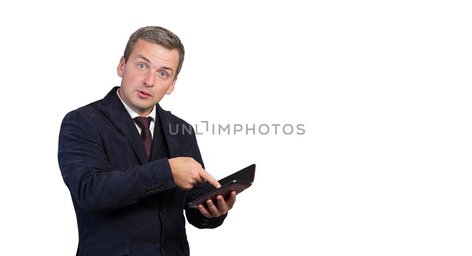 Portrait of a puzzled impressed man reading news on a gadget. by gelog67