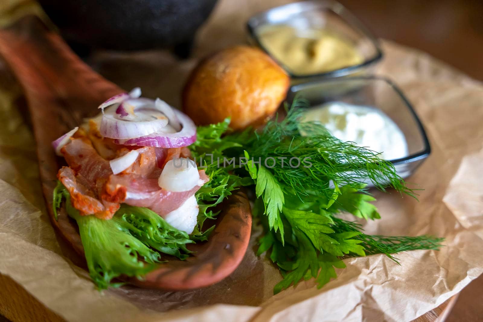 Meat on a wooden spoon plate served with herbs and sauces by audiznam2609